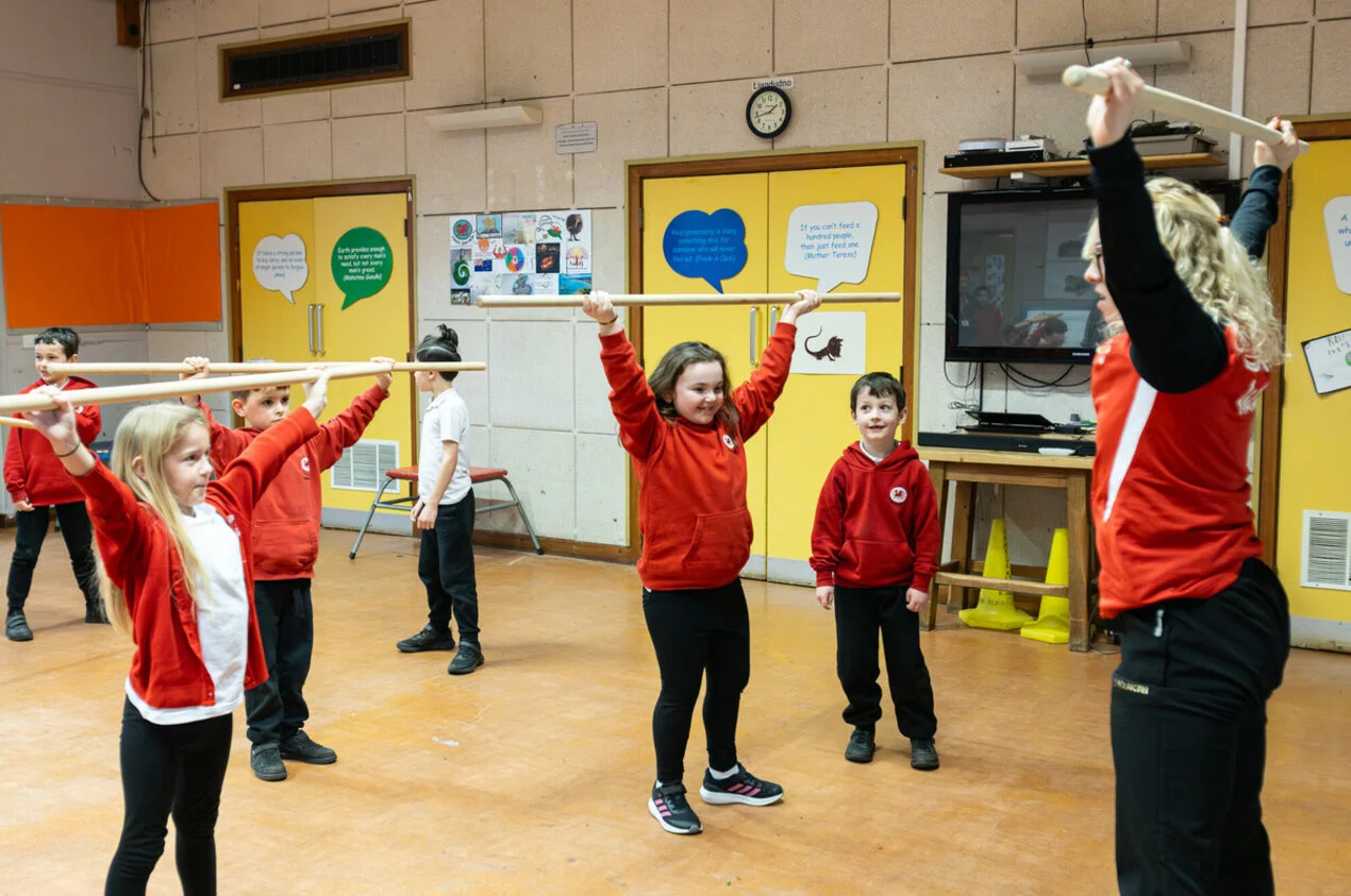 Schoolchildren try out some weightlifting techniques with Catrin Jones